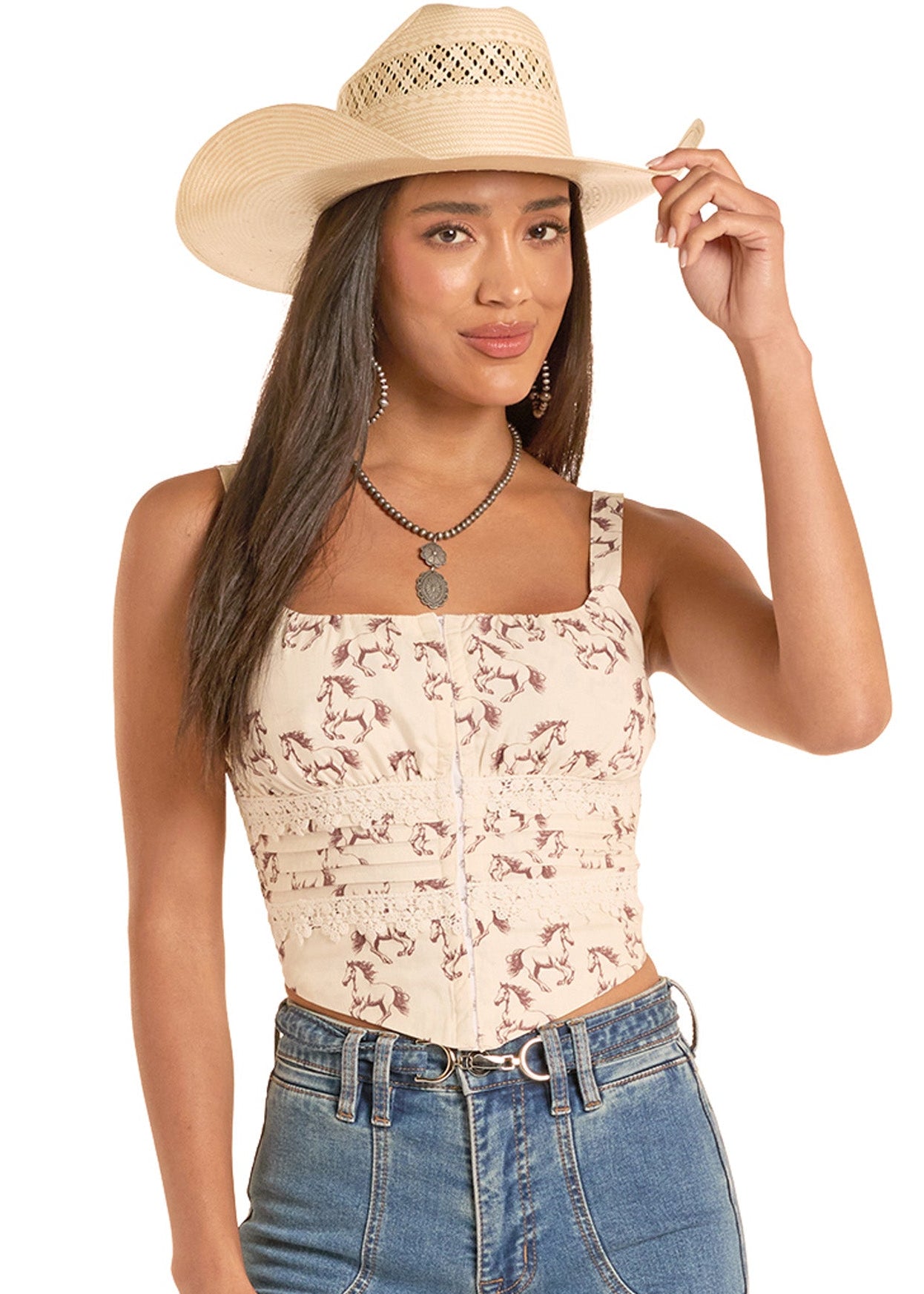 Woman wearing a horse tank top and cowboy hat, standing against a neutral background