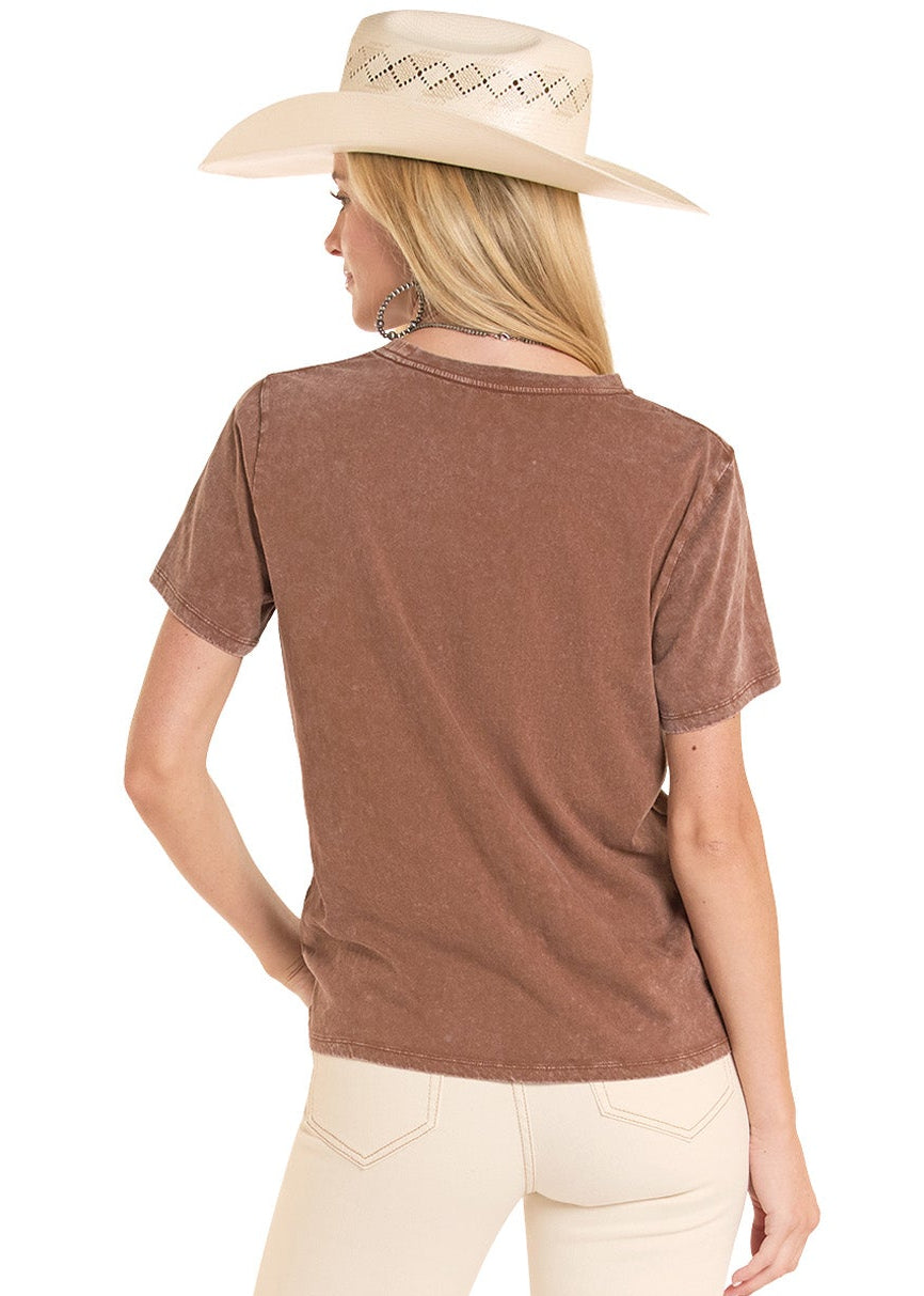 Woman wearing a brown shirt and beige pants with a hat on a white background