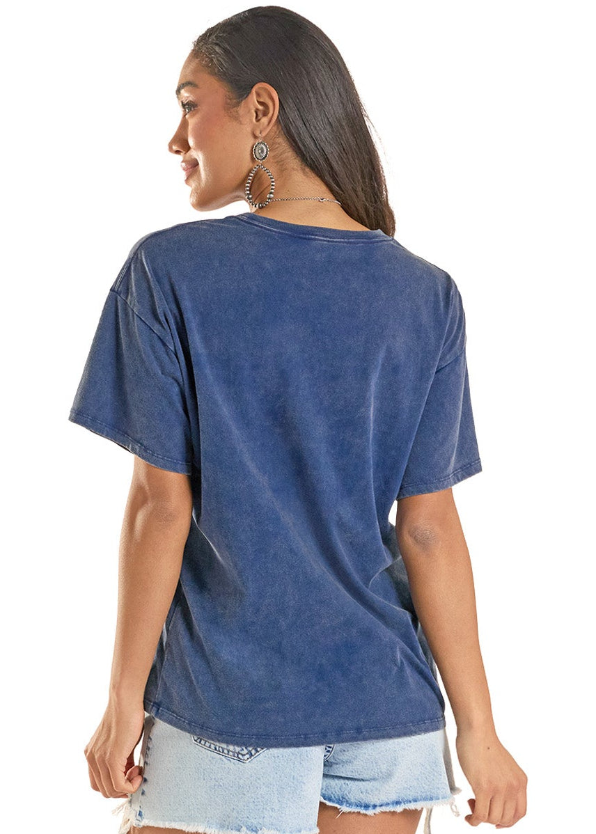 Woman wearing a blue t-shirt and denim shorts with white cowboy boots on a white background