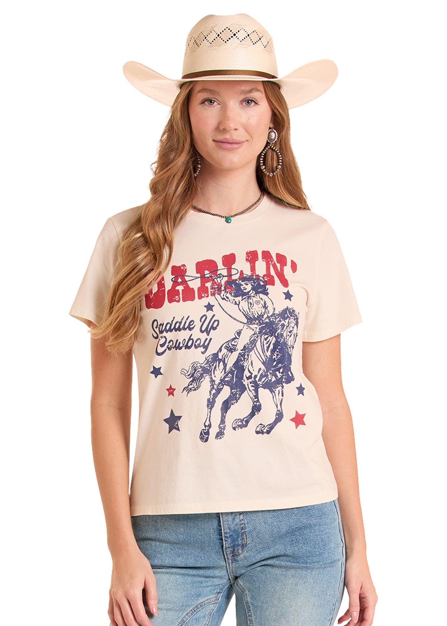 Woman wearing a beige t-shirt with a graphic design and a cowboy hat on a white background