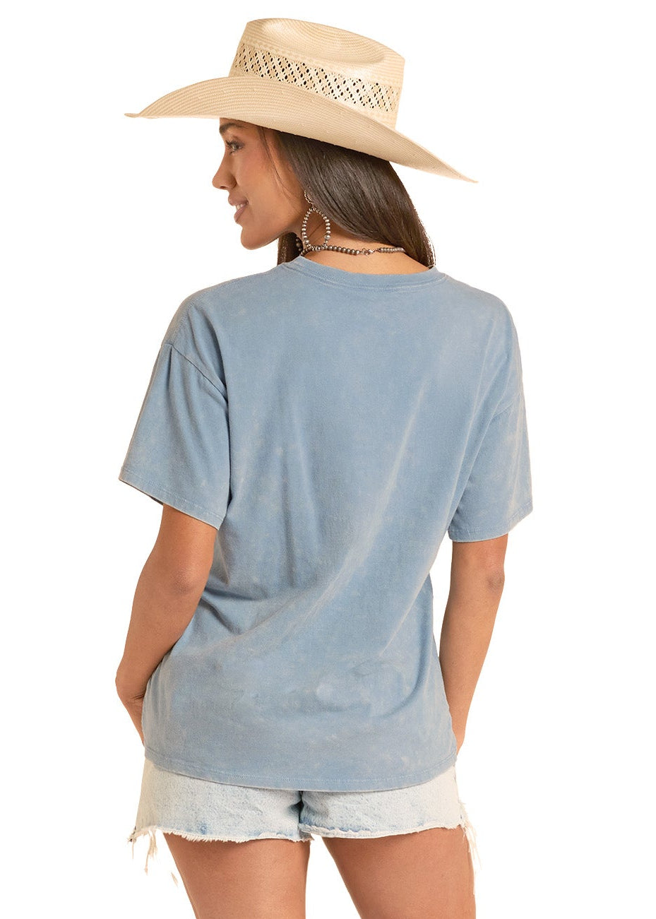 Woman wearing a light blue t-shirt, white shorts, and white cowboy boots on a white background
