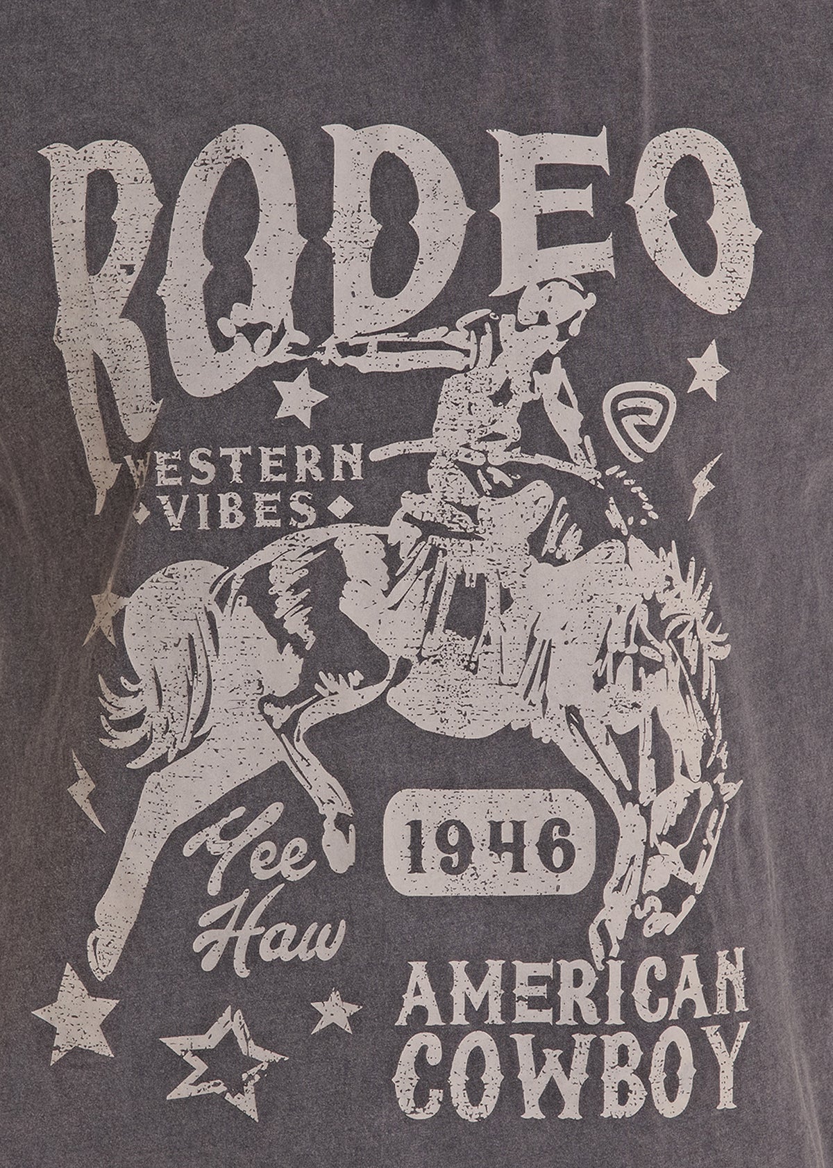 A close-up of a dark gray graphic t-shirt featuring a distressed white print of a cowboy riding a bucking horse, with the text 'RODEO', 'WESTERN VIBES', 'Yee Haw', '1946', and 'AMERICAN COWBOY'.