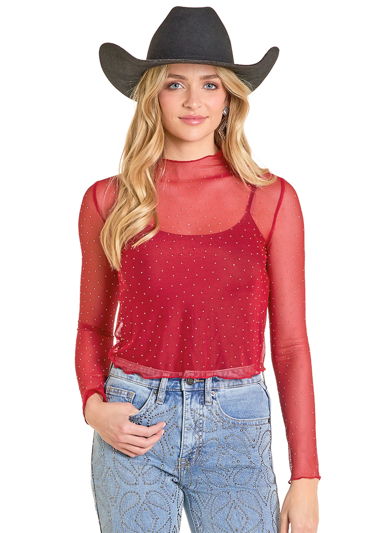 Woman wearing a red sheer top and blue jeans with a black cowboy hat on a white background