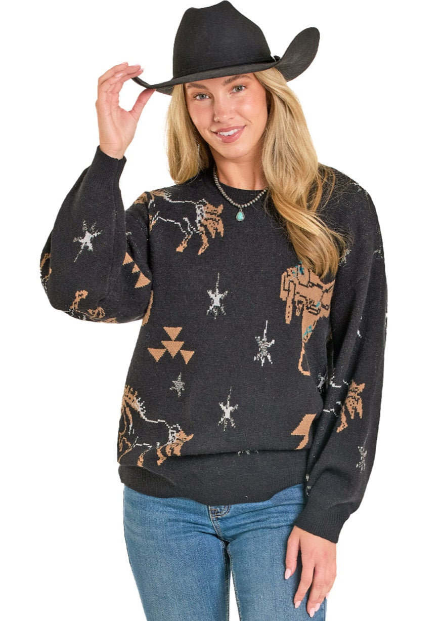 Woman wearing a black patterned long-sleeve shirt and blue jeans, holding a black cowboy hat.