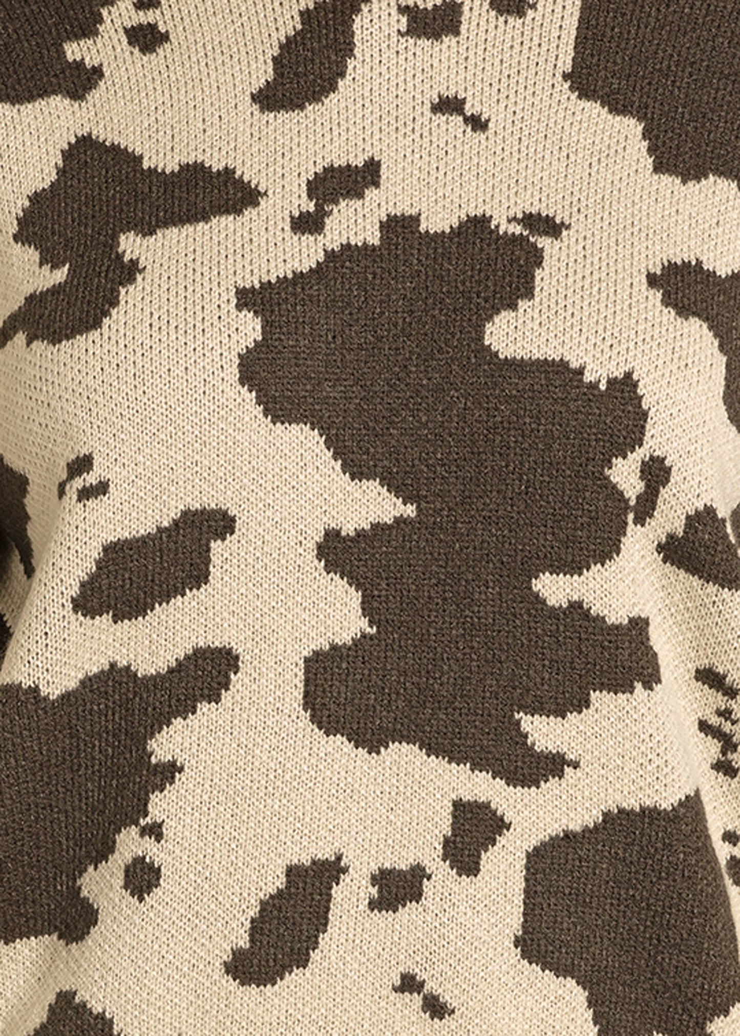 Close-up of soft knit fabric in a brown and beige cow print—irregular, cowhide-like blotches make the Rock & Roll Denim Cowhide Knit Sweater perfect for a cozy, relaxed fit.