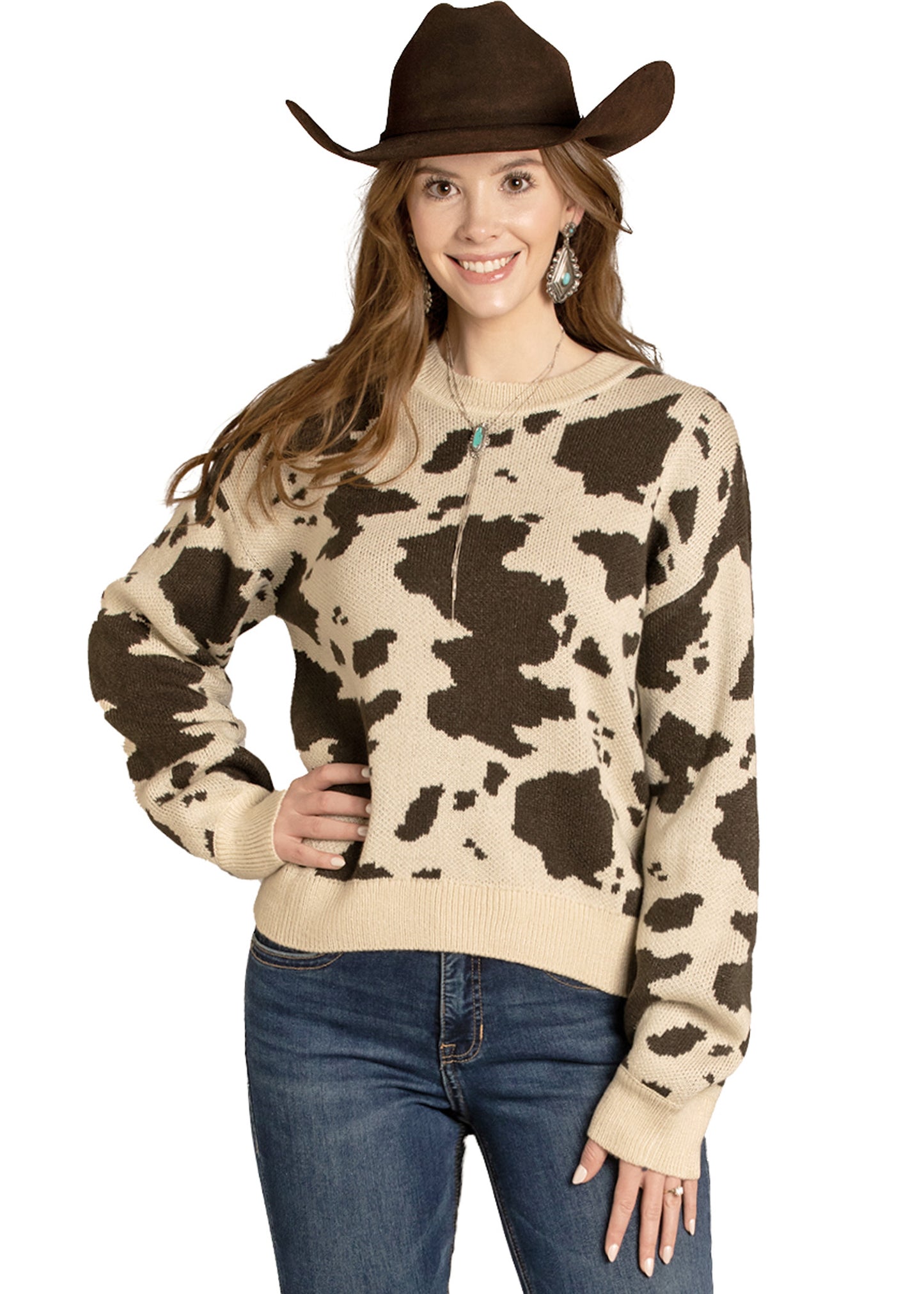 Woman wearing a cow print sweater and brown cowboy hat on a white background
