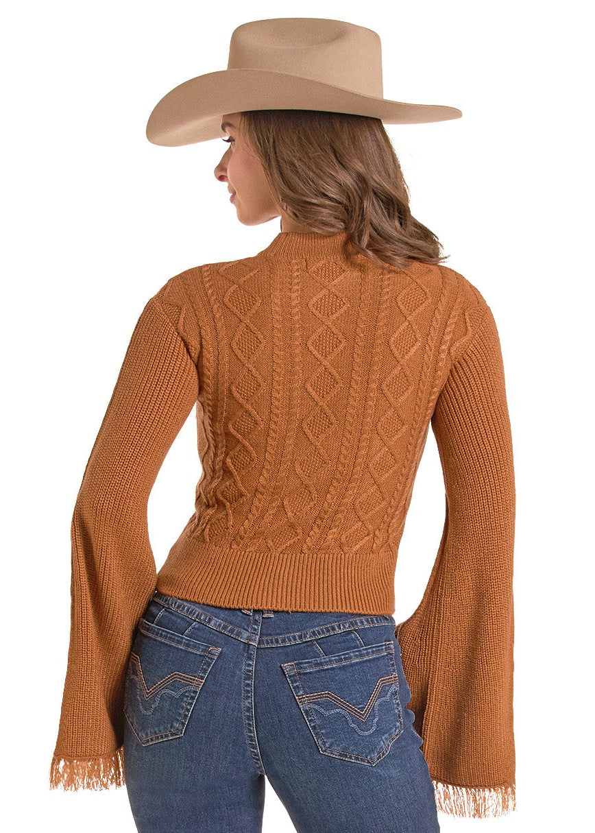 A woman shown from the back wearing a rust-orange long-sleeve knit sweater with fringe details, blue jeans, and a beige cowboy hat against a plain white background.