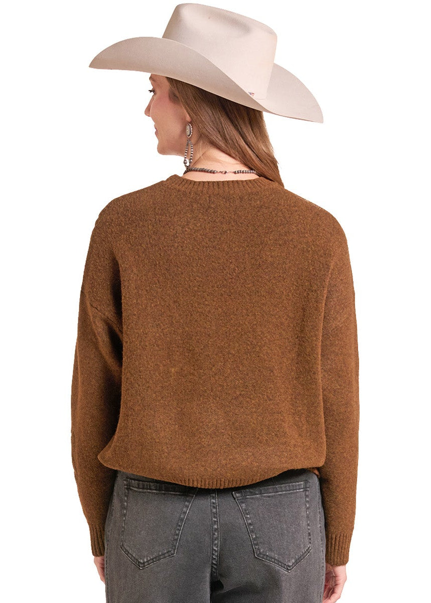 A woman shown from the back wearing a brown knit sweater, gray jeans, and a light beige cowboy hat against a plain white background.