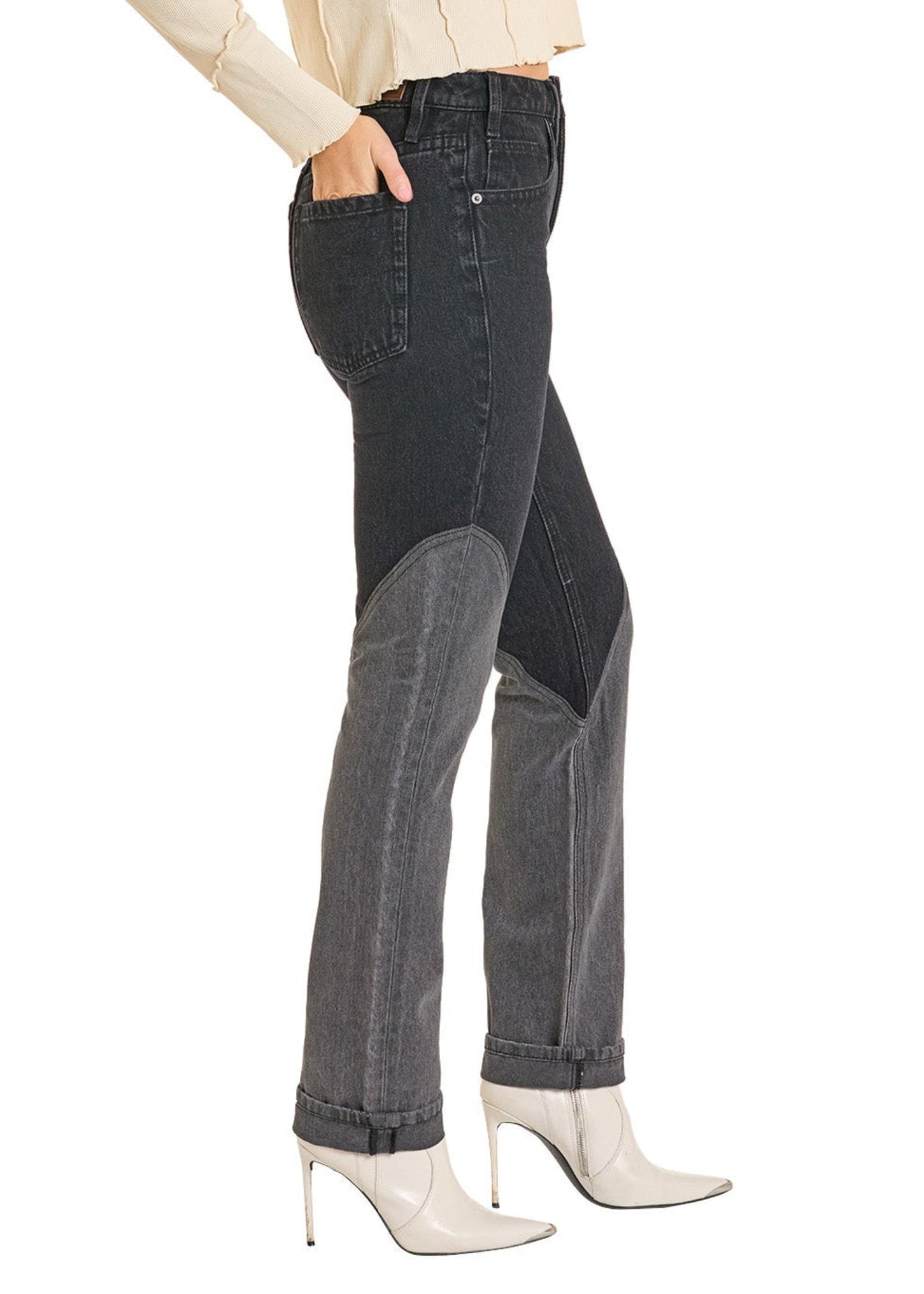 Woman wearing a beige shirt, black jeans, and a black cowboy hat on a white background