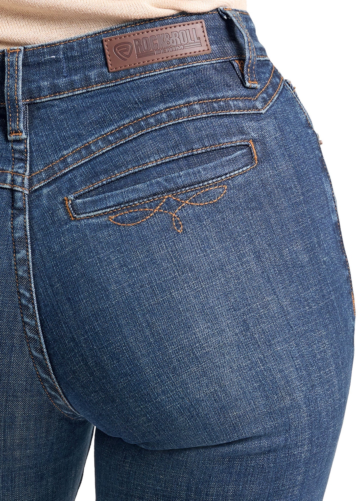 Close-up of the back waistband and pocket area of blue denim jeans, showing a brown leather brand patch and contrast stitching.