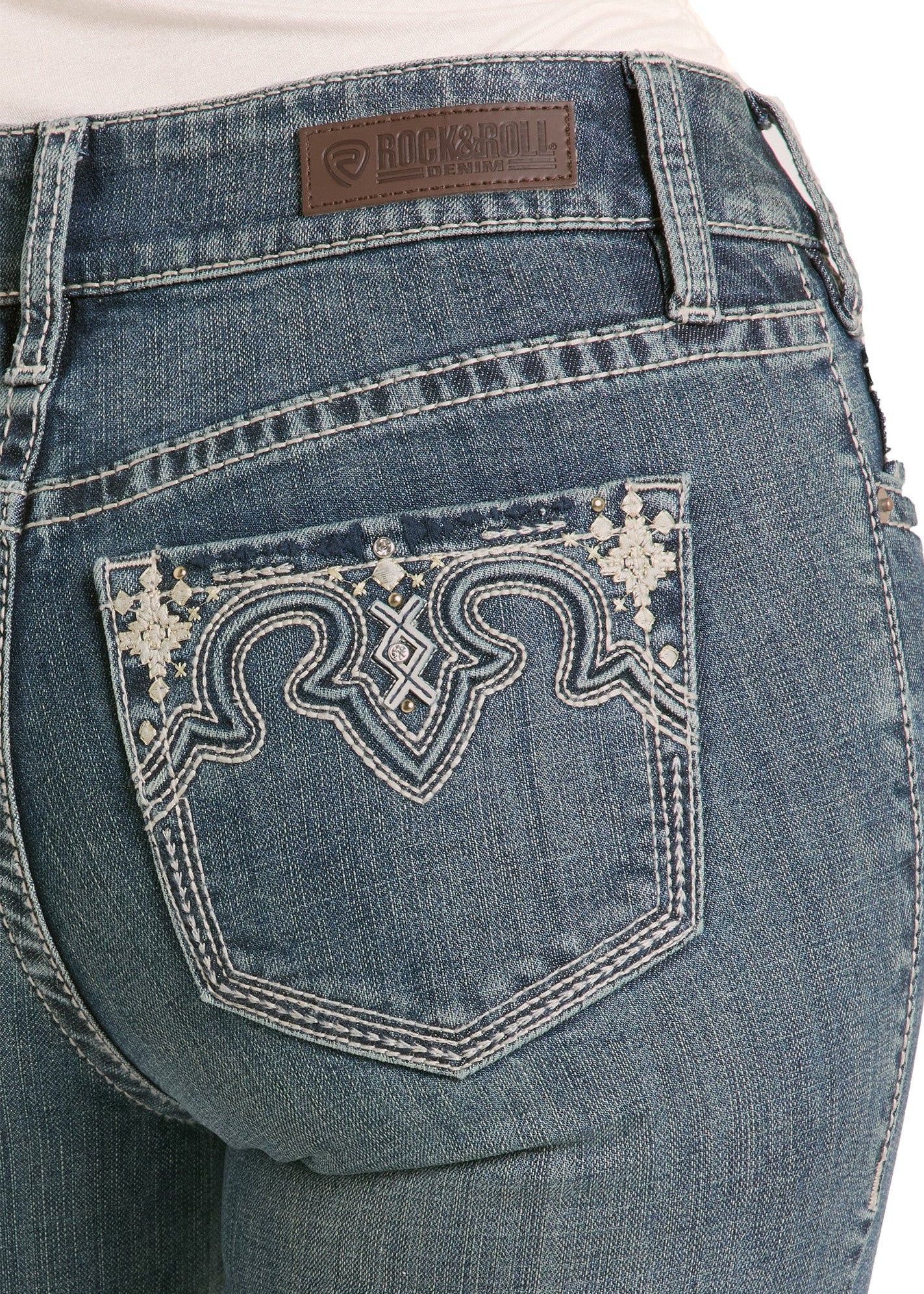 Close-up of blue jeans with decorative back pocket and Rock & Roll denim brand label.