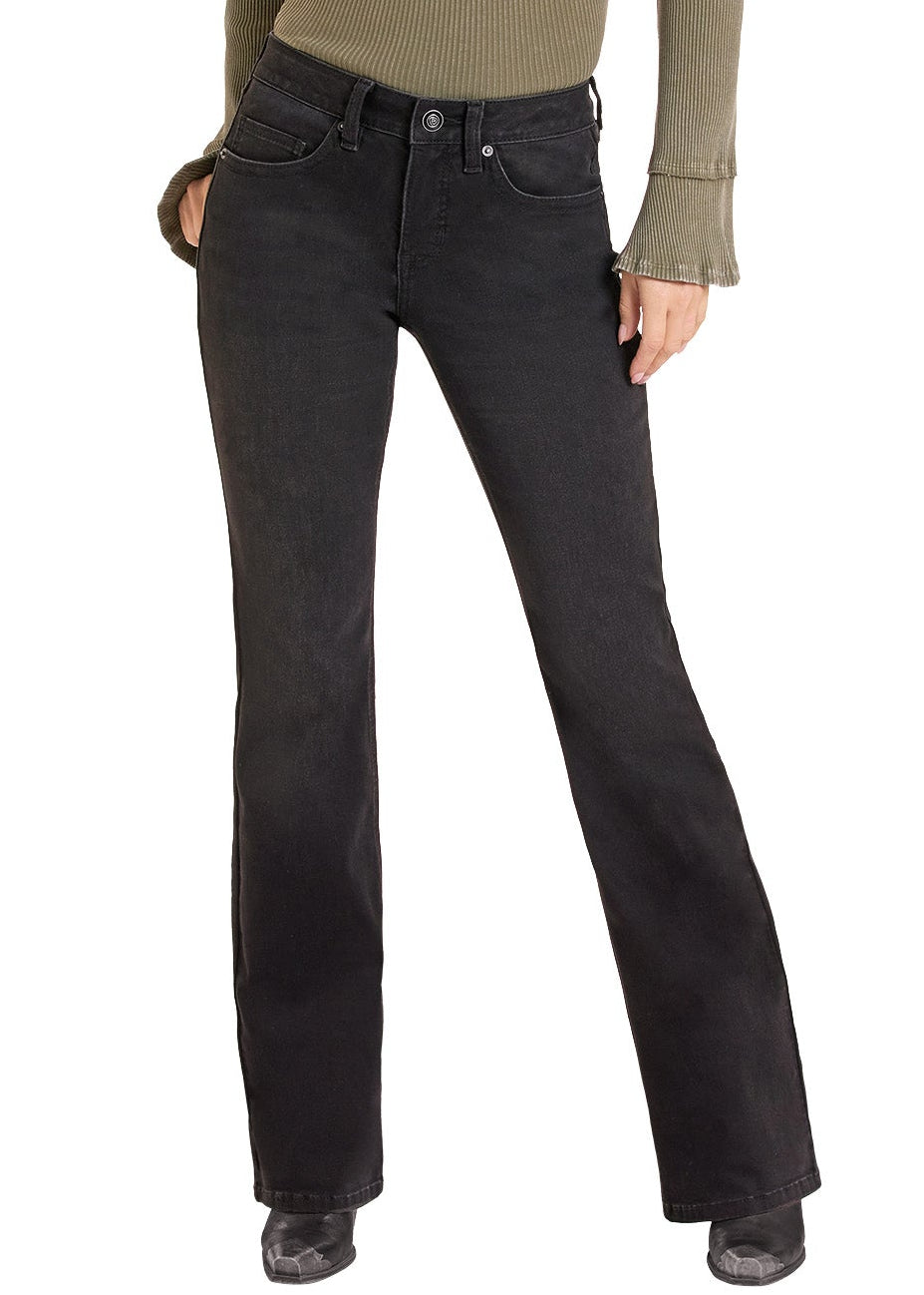 A woman modeling a long-sleeve olive green top, black jeans, and a black cowboy hat against a plain white background.