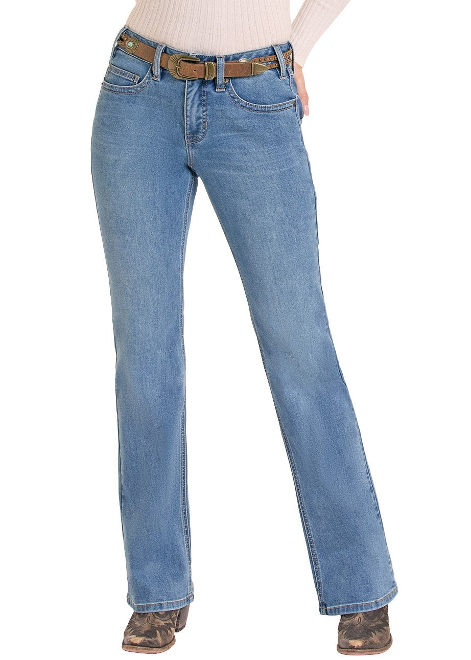 A woman modeling a western-style outfit consisting of a beige ribbed long-sleeve top, light blue flare jeans, a brown belt, and a tan cowboy hat, set against a plain white background.