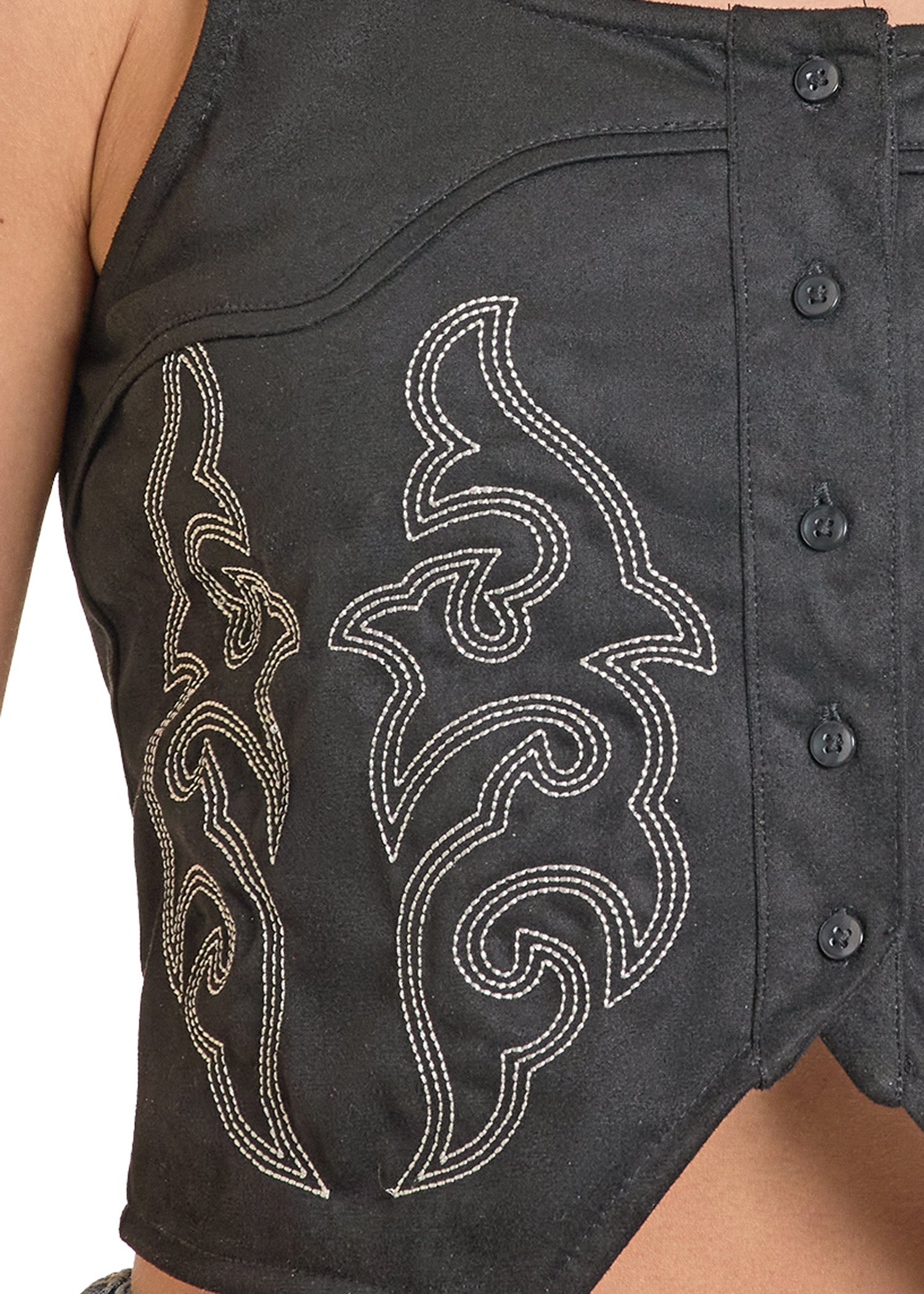 Black sleeveless top with white embroidered designs on a person wearing it.