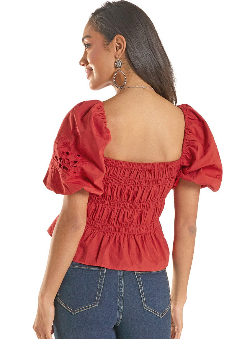 Woman wearing a red blouse and blue jeans on a white background