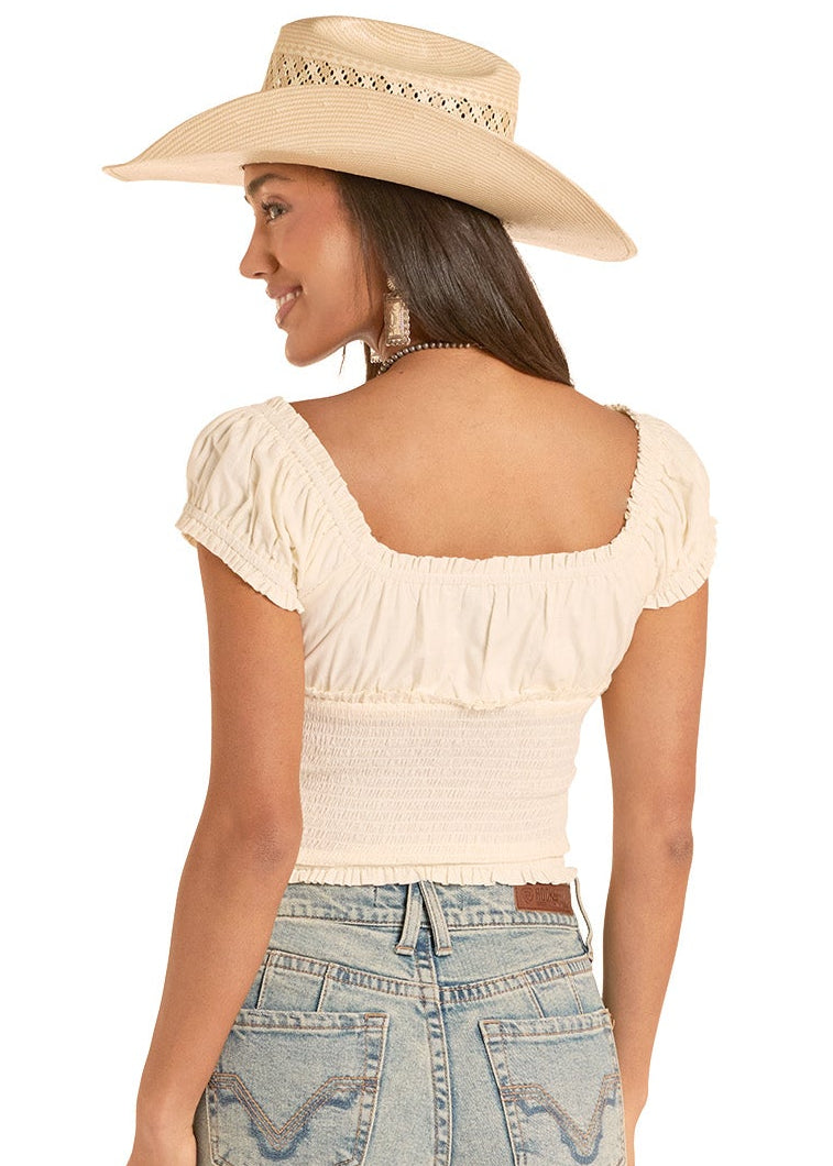Woman wearing a beige top and light blue jeans with a white background