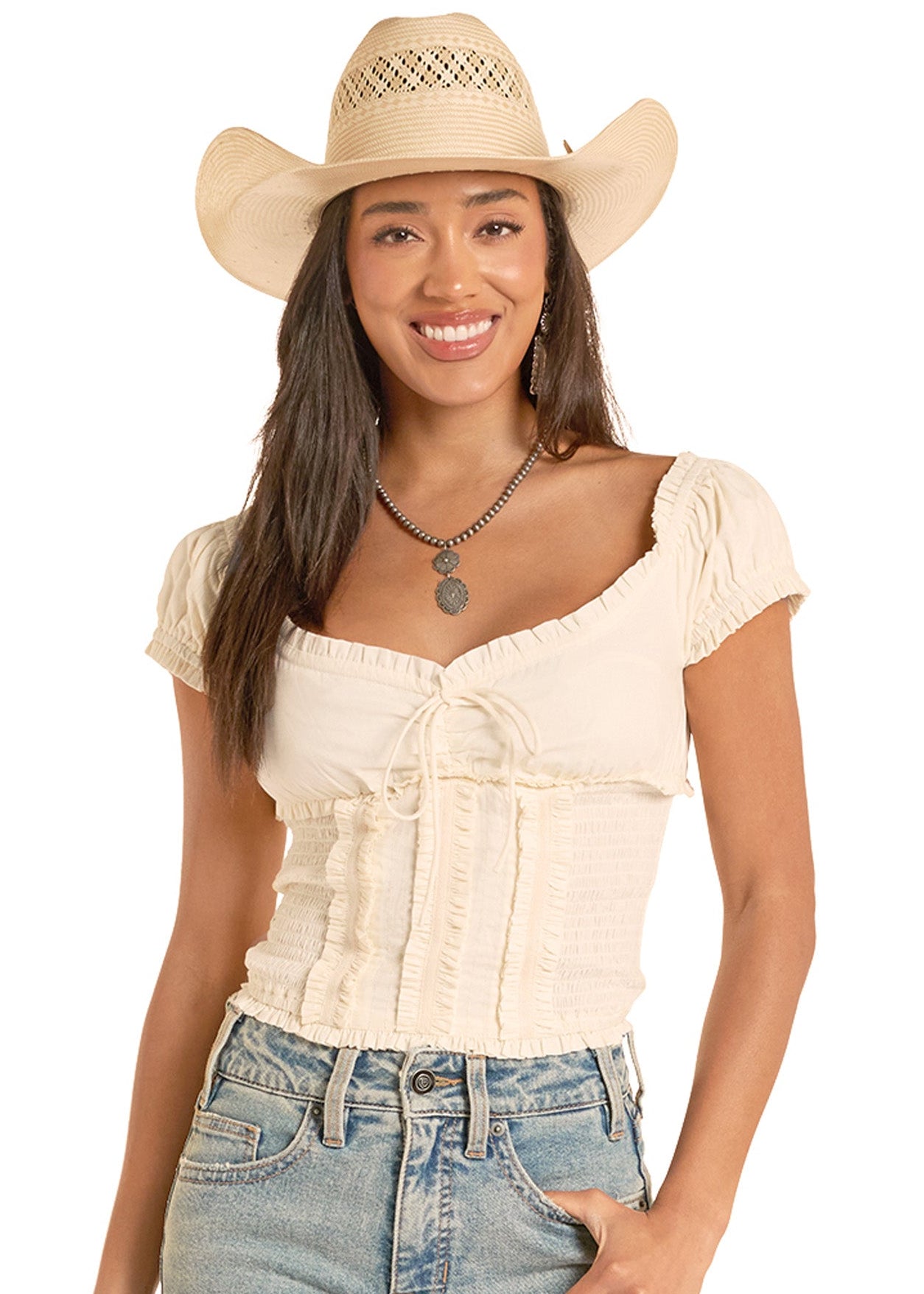 Woman wearing a beige top, jeans, and a cowboy hat on a white background