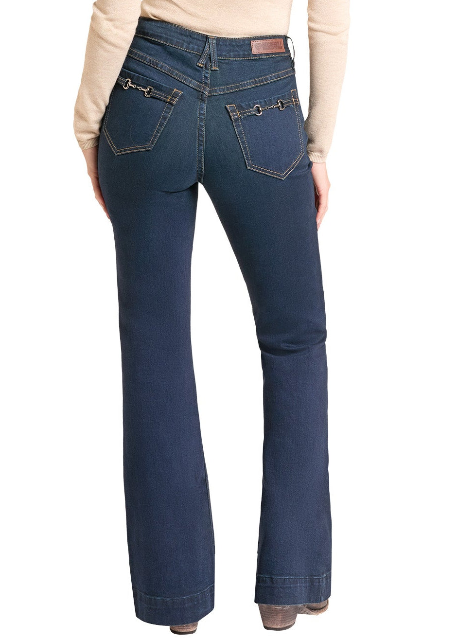 A woman shown from the back wearing dark blue flare jeans, a beige long-sleeve top against a plain white background.