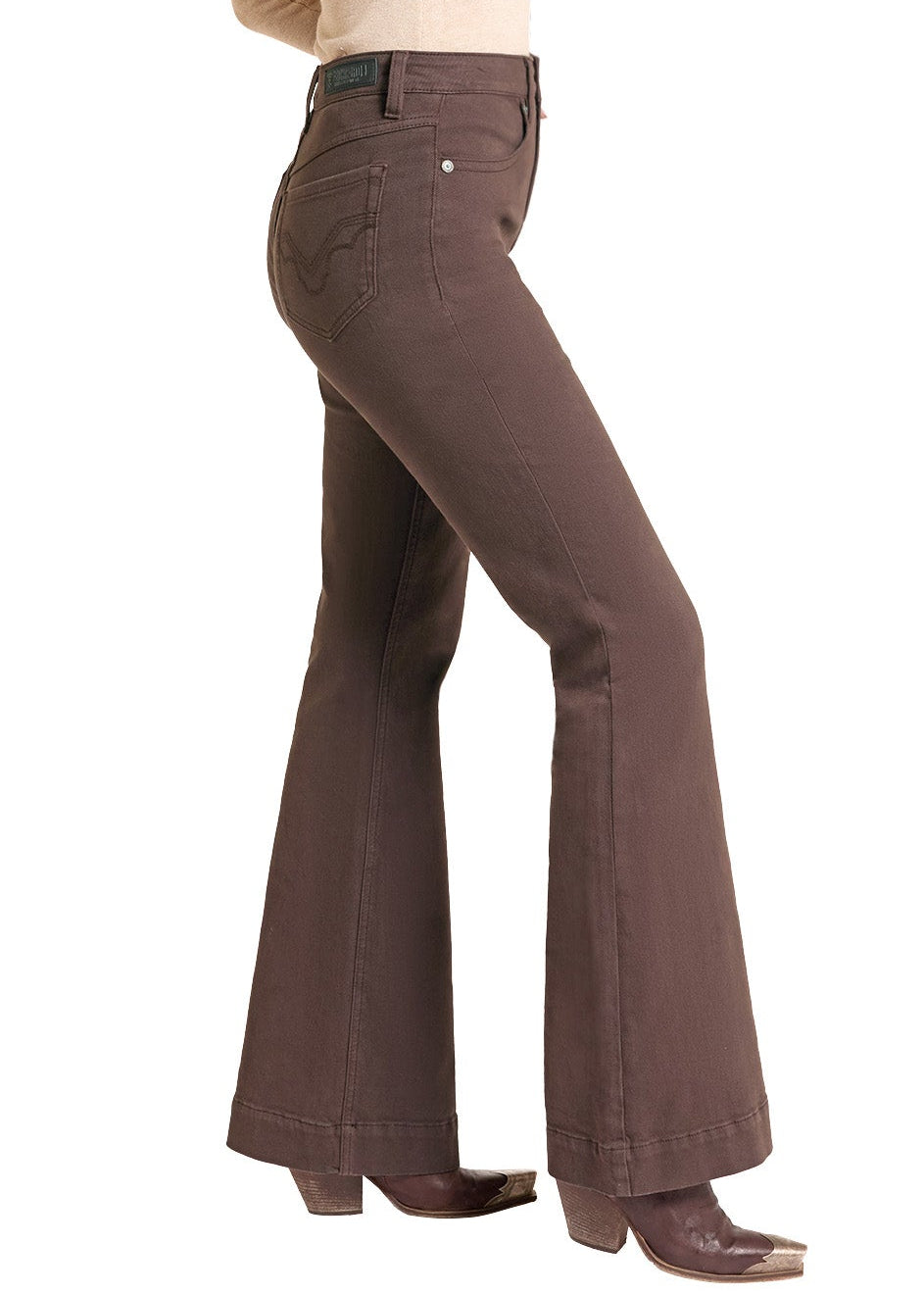 A woman modeling brown flared jeans, a beige long-sleeve top, and a brown cowboy hat against a plain white background.