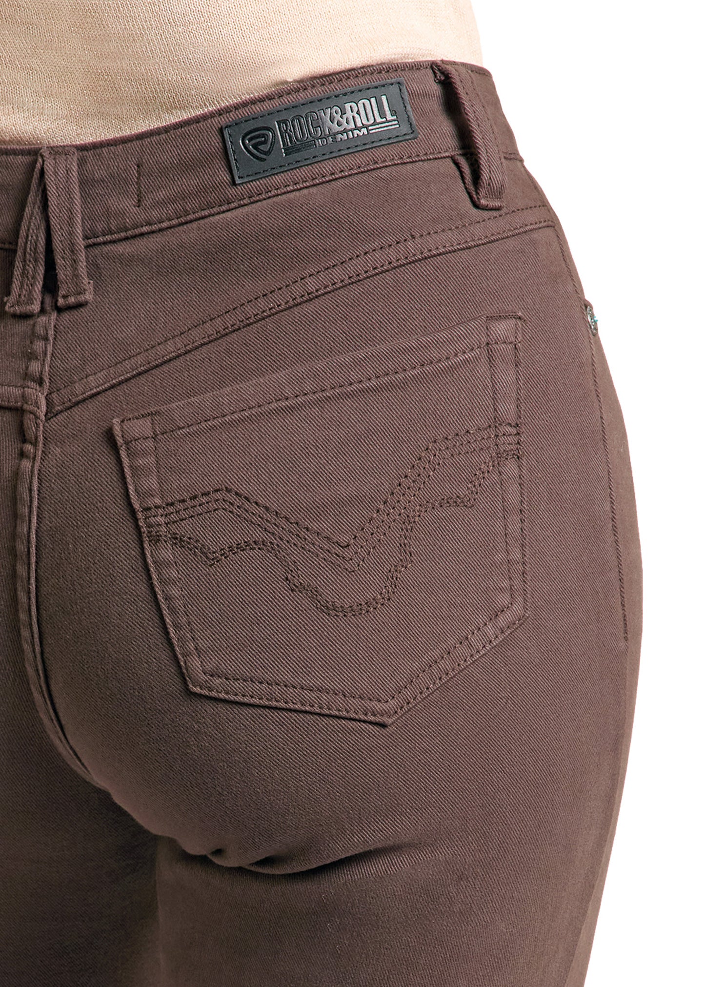 Close-up of the back waistband and pocket area of dark brown denim jeans, showing a visible Rock & Roll brand patch at the back waist and decorative stitching on the pocket.