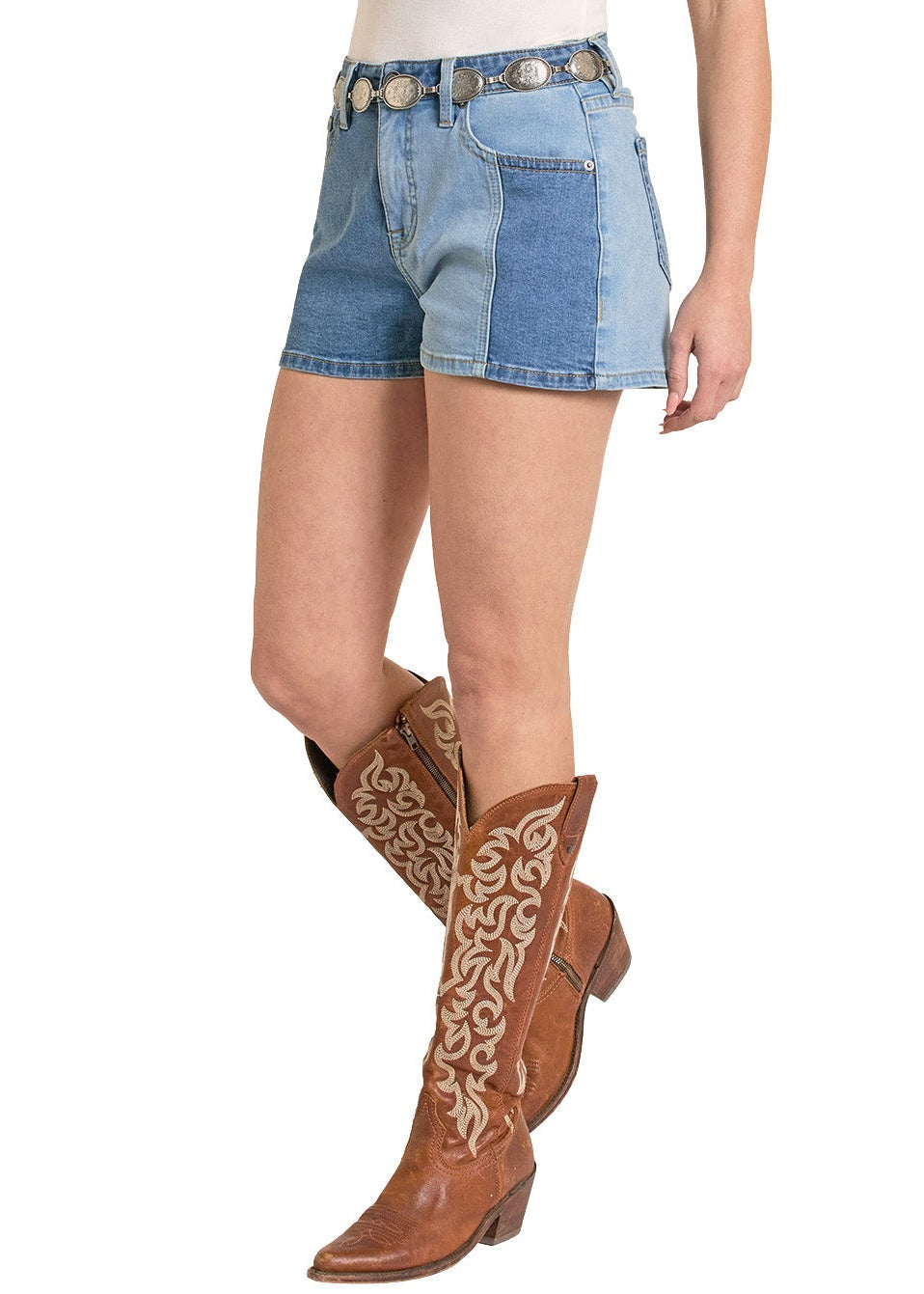 Woman wearing a white top, denim shorts, and brown cowboy boots on a white background