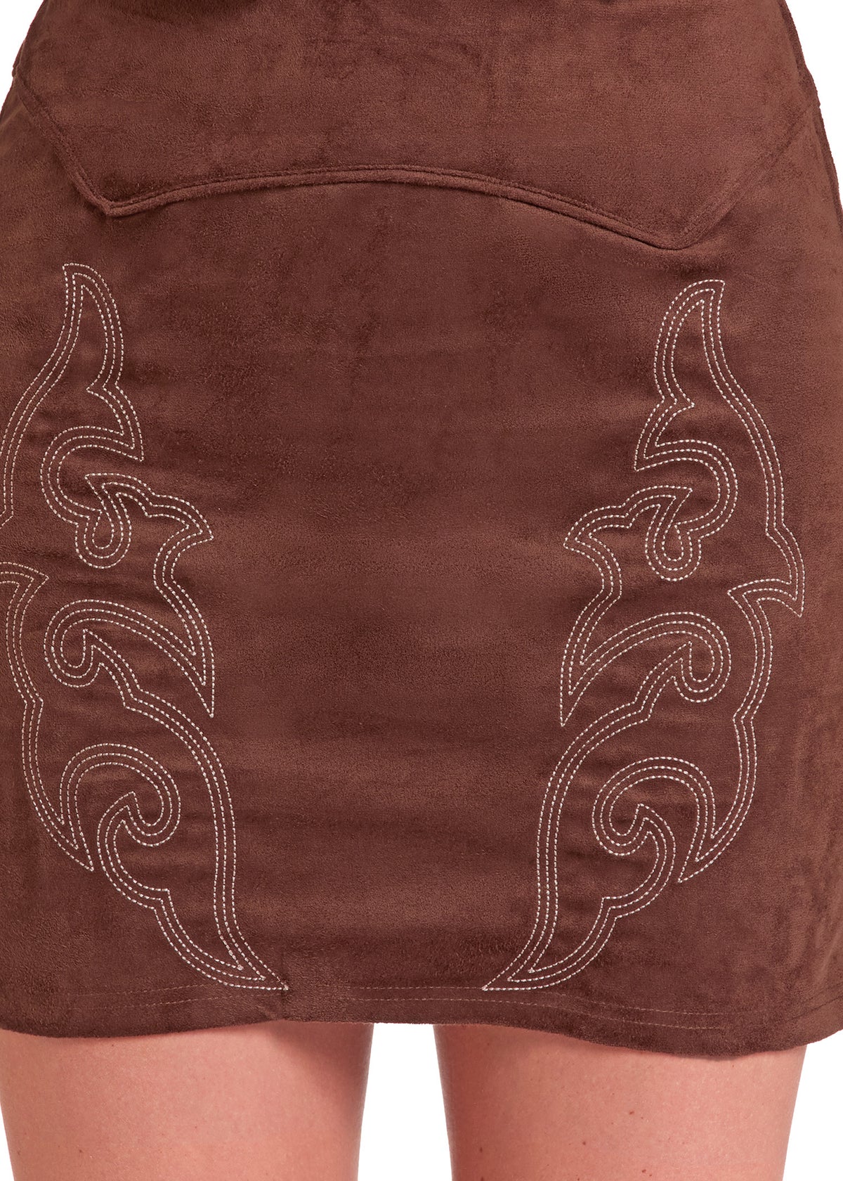 Close-up of the back of a brown faux-suede mini skirt with white embroidered western-style scroll patterns, worn by a model.