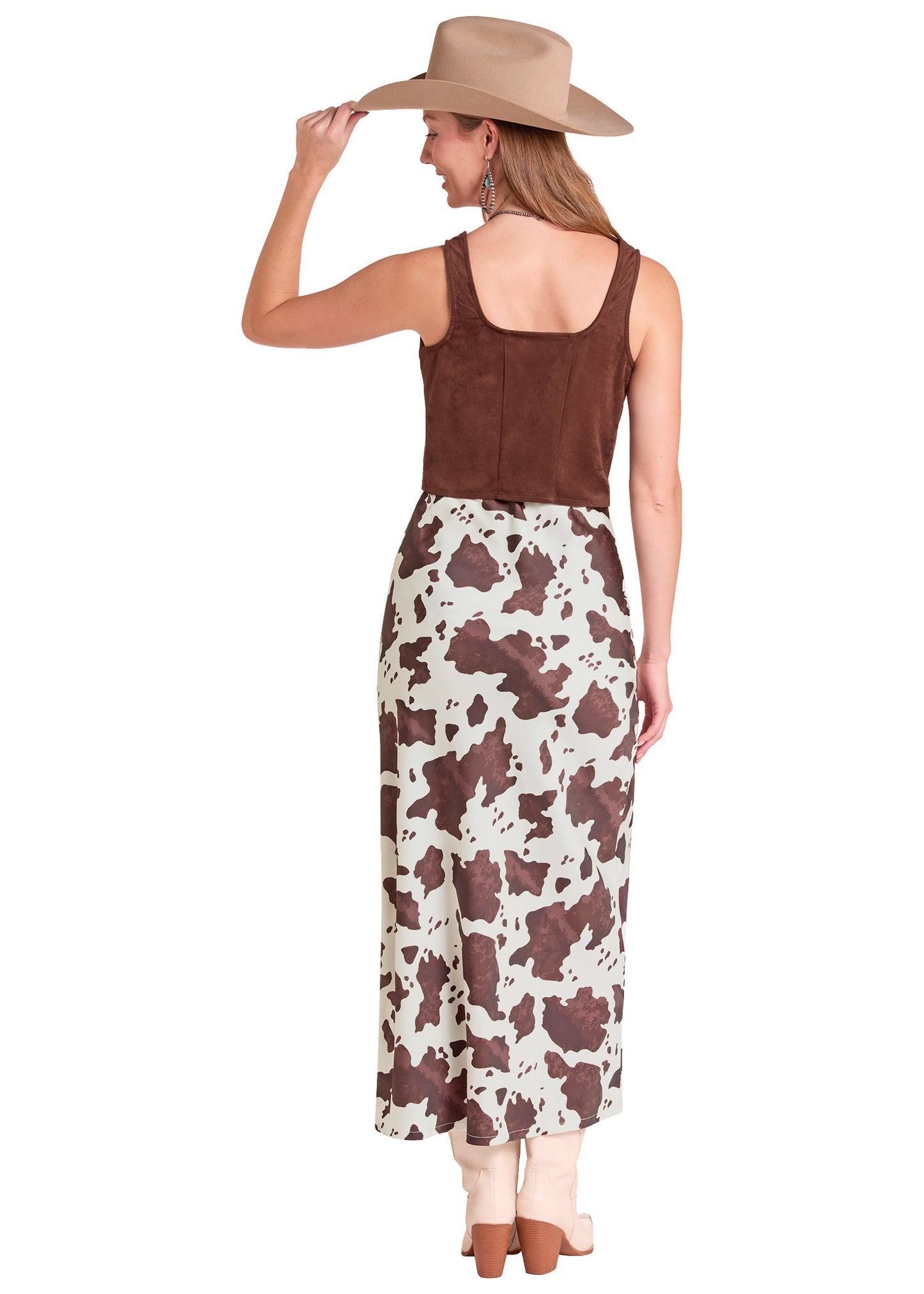 A woman shown from the back wearing a sleeveless brown top and a long skirt with a brown and cream cow-print pattern.