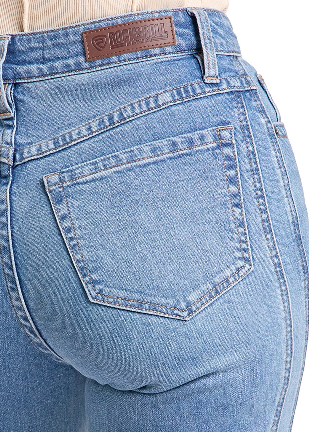 Close-up of the back waist and back pocket of light blue denim jeans, showing a brown leather brand patch at the waistband.