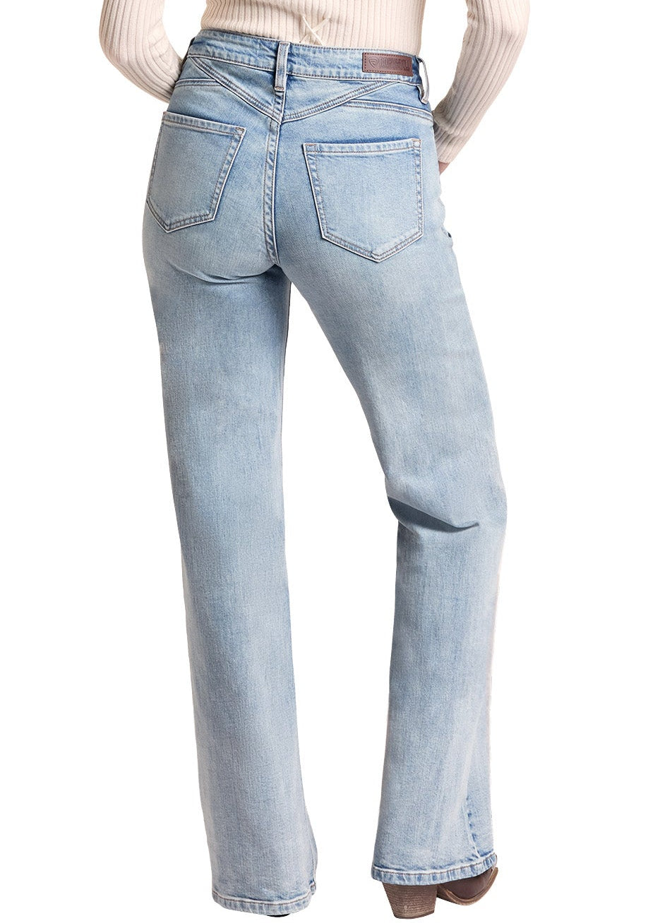 A woman shown from the back wearing a beige cowboy hat, a cream ribbed long-sleeve top, and light-wash blue jeans against a plain white background.