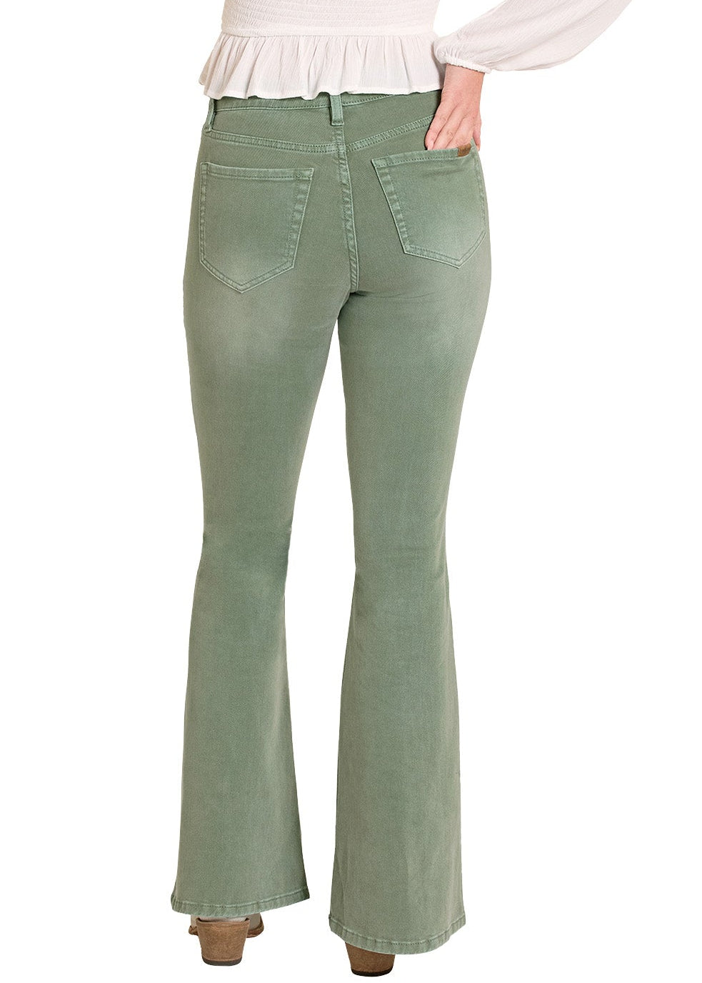 Woman wearing a white blouse, green flared jeans, and a beige hat on a white background