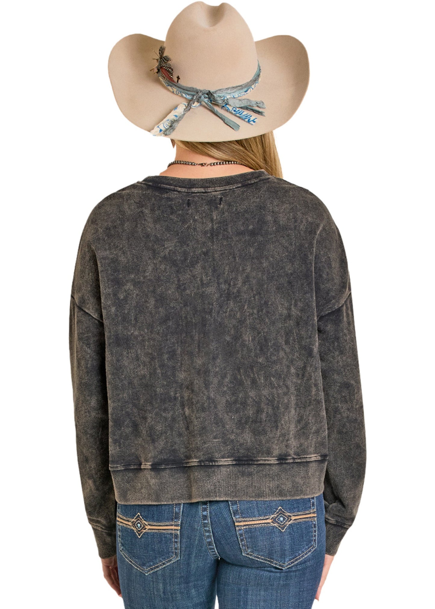Person wearing a distressed black sweater and blue jeans with a beige cowboy hat on a white background
