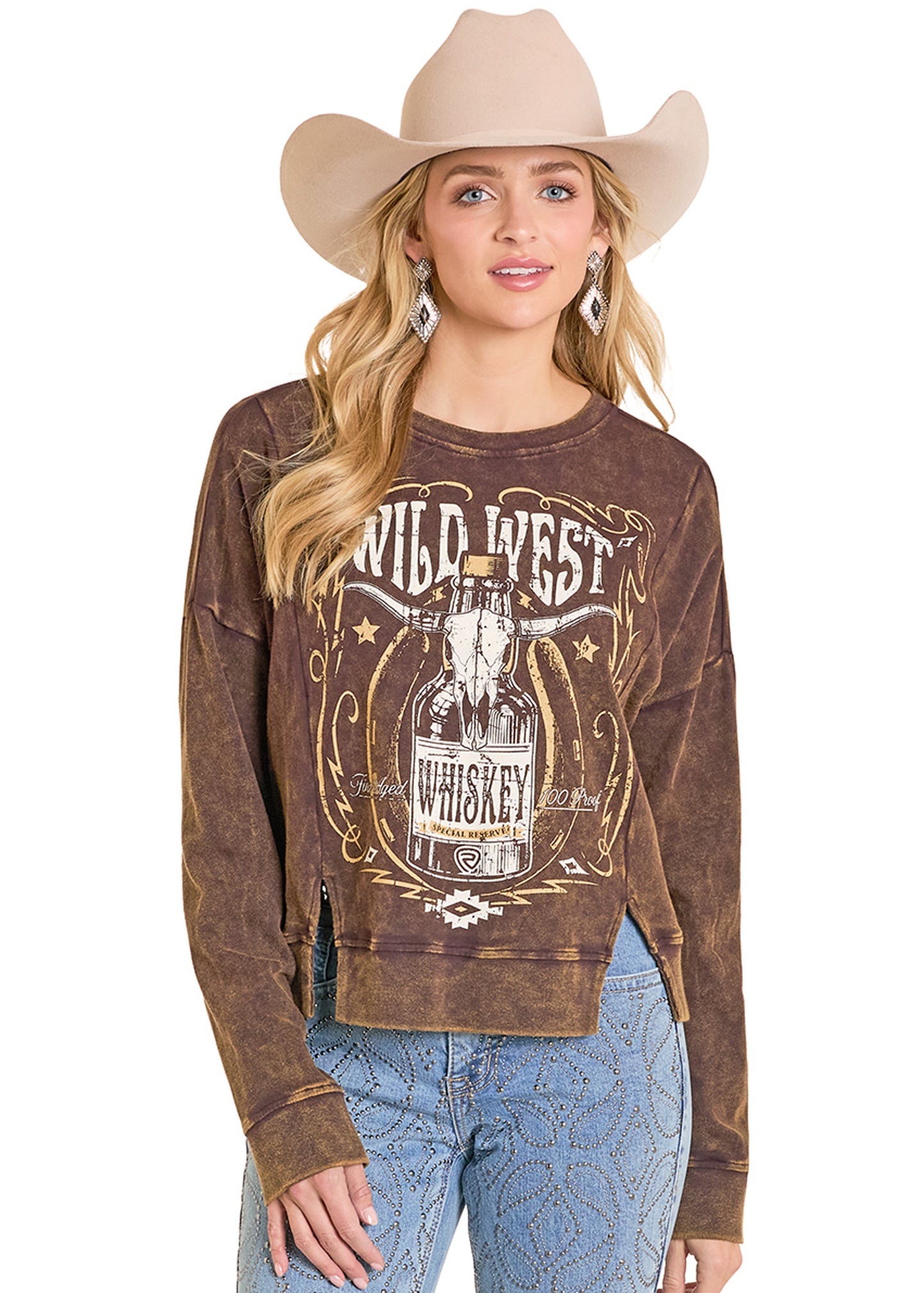 Woman wearing a brown sweatshirt with 'Wild West Whiskey' design, beige cowboy hat, and blue jeans on a white background.