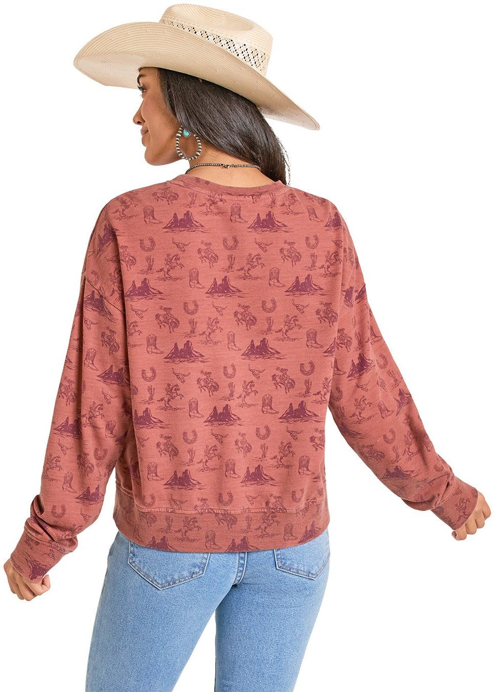 Woman wearing a patterned long-sleeve shirt and blue jeans on a white background