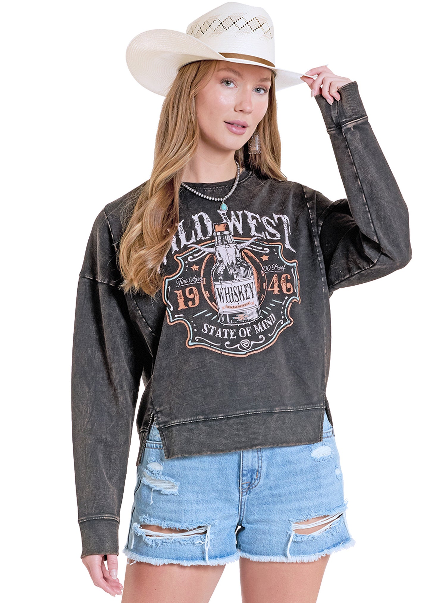 Woman wearing a black 'Wild West' sweatshirt with a white cowboy hat on a white background