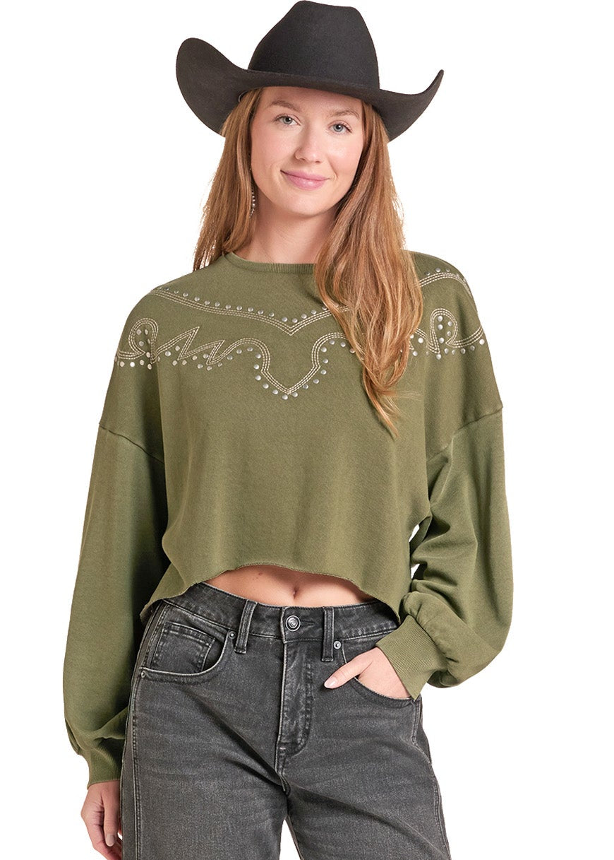 A woman modeling a cropped sage green long-sleeve sweatshirt with western-style embroidery and bead details, paired with dark gray jeans,