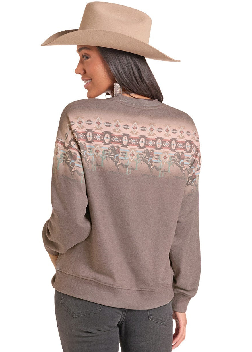 A woman shown from the back wearing a taupe crewneck sweatshirt with a colorful geometric pattern across the shoulders, dark gray pants, and a beige cowboy hat against a white background.