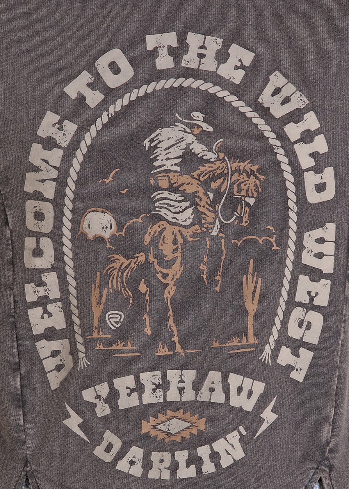 Close-up of a dark heather gray graphic print on a shirt featuring a cowboy riding a bucking horse, with distressed white text reading 'WELCOME TO THE WILD WEST' and 'YEEHAW DARLIN''.