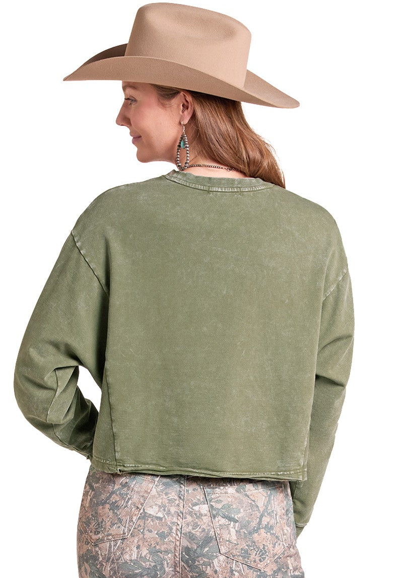 A woman shown from the back wearing an olive green cropped sweatshirt, camouflage-print pants, and a tan wide-brim hat against a plain white background.