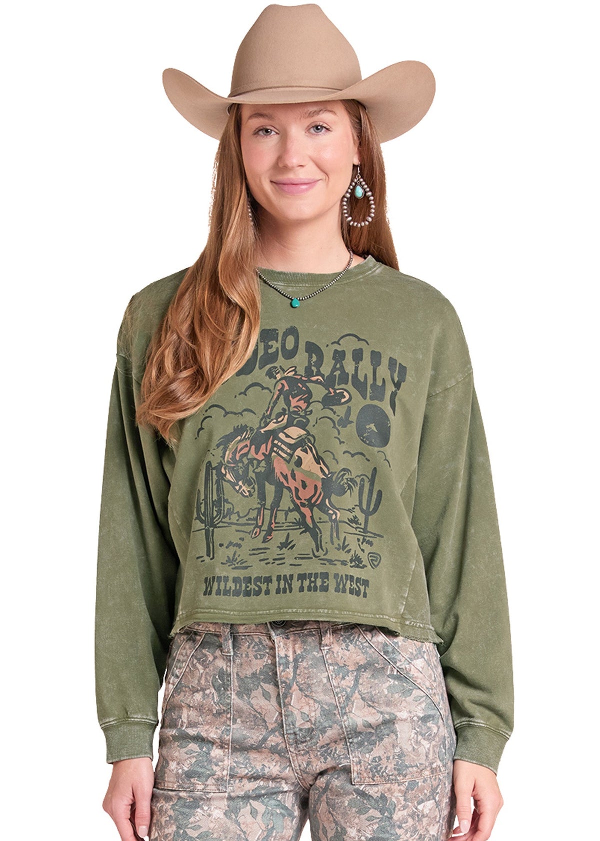 Woman in a "Rodeo Rally" pullover green sweatshirt and a tan cowboy hat