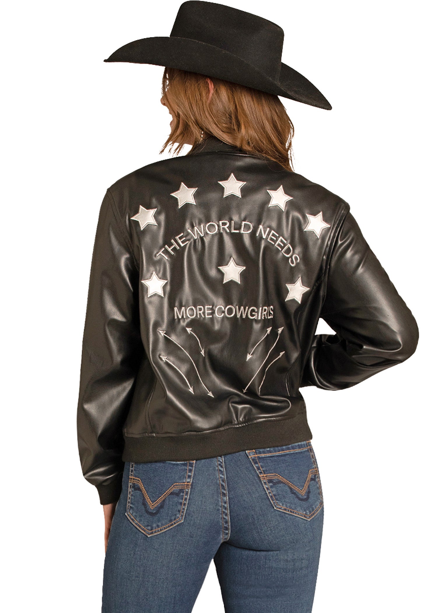 Person wearing a black leather jacket with stars and text, paired with blue jeans and a cowboy hat.