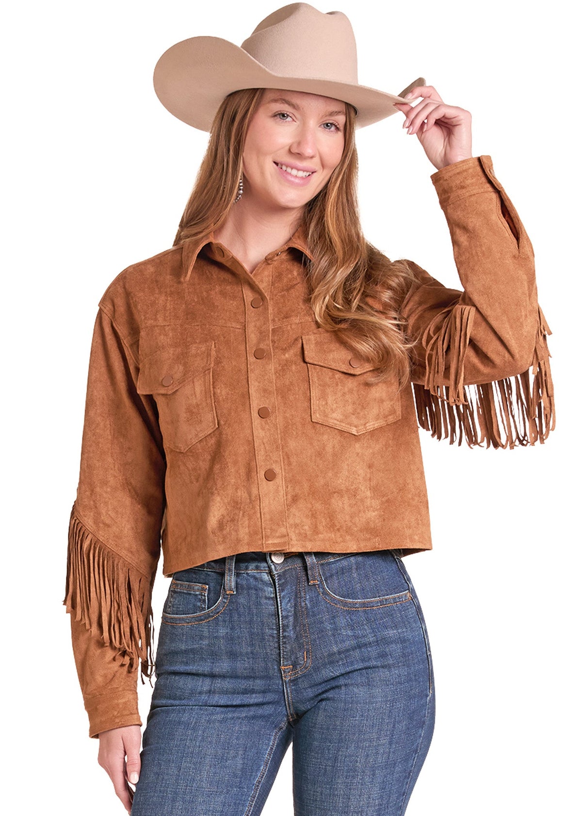 A woman wearing a cropped tan suede fringe shirt jacket, blue jeans, and a beige cowboy hat, posing against a white background.