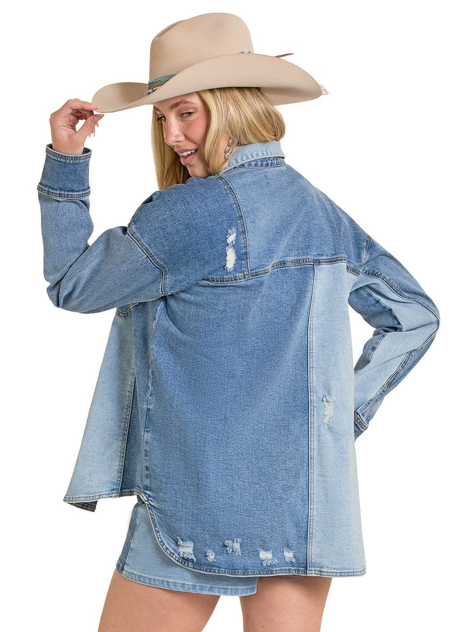 Woman wearing a denim jacket, skirt, and cowboy boots on a white background
