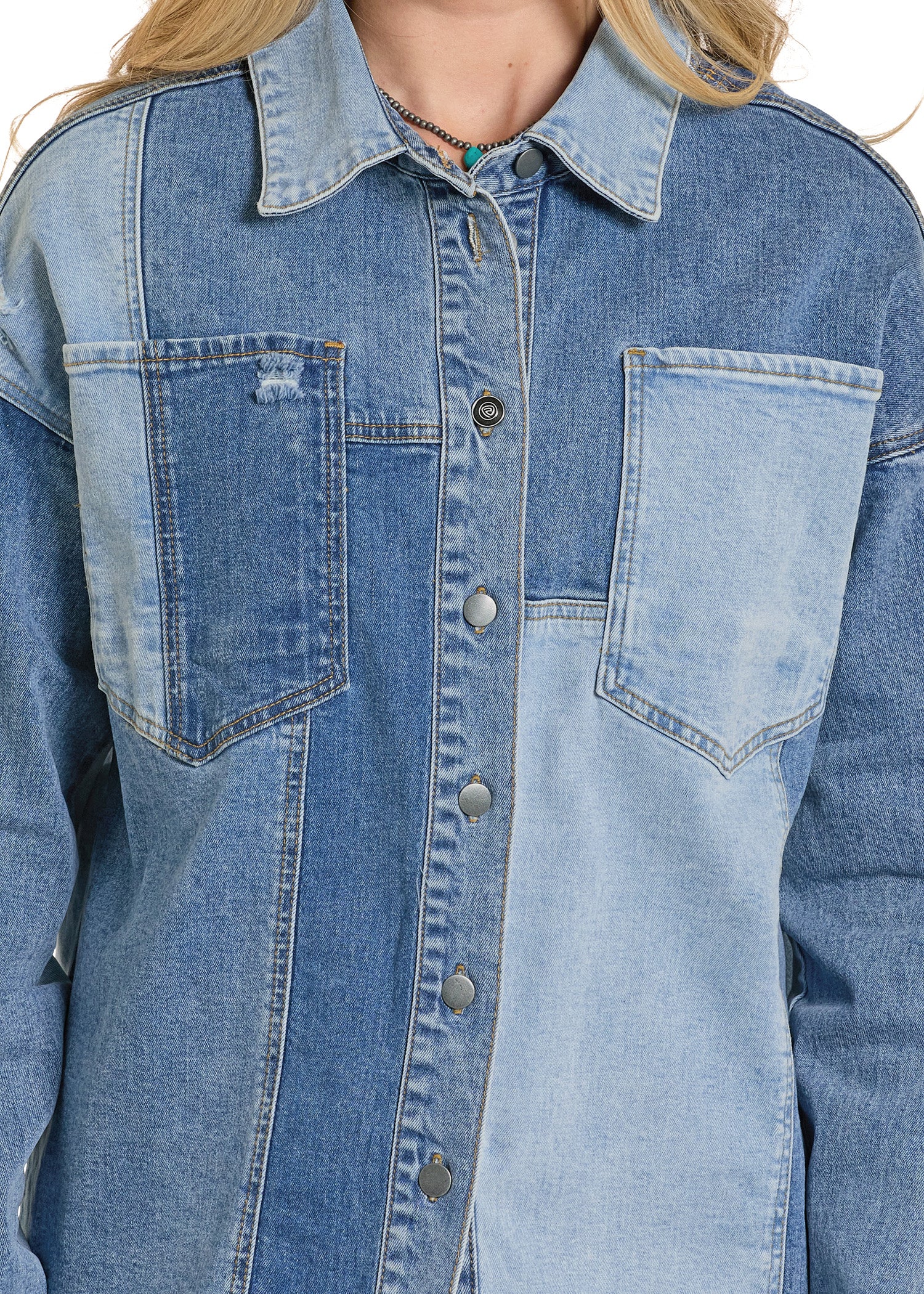 Close-up of a blue denim jacket with button details