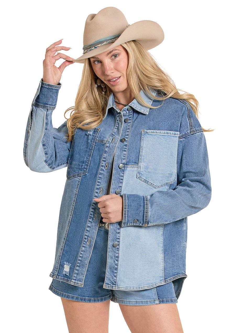 Woman wearing a denim jacket, shorts, and cowboy boots on a white background