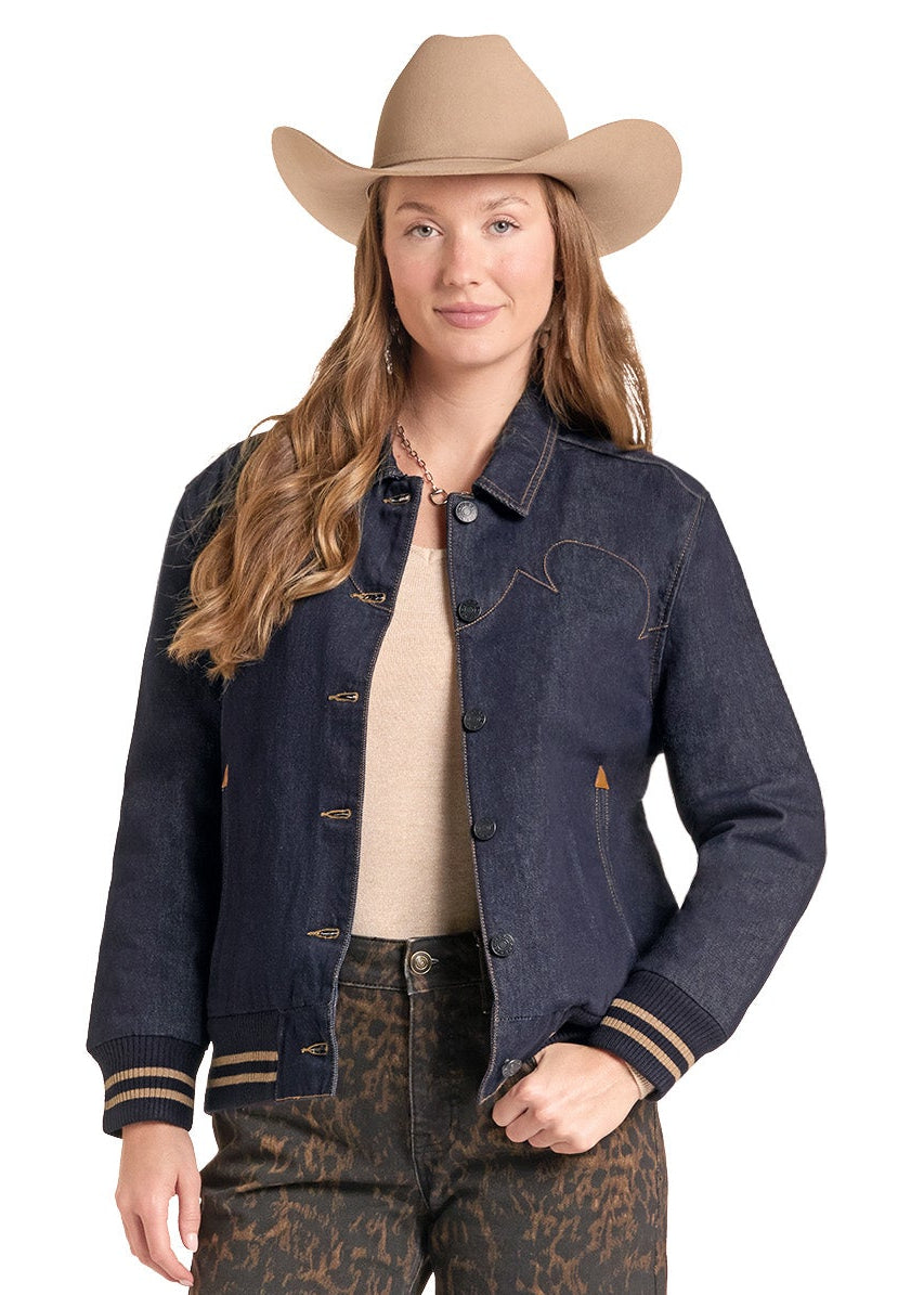 A woman modeling western-style clothing, including a tan cowboy hat, a dark blue denim jacket, a beige top, brown patterned pants, and brown leather boots, against a plain white background.
