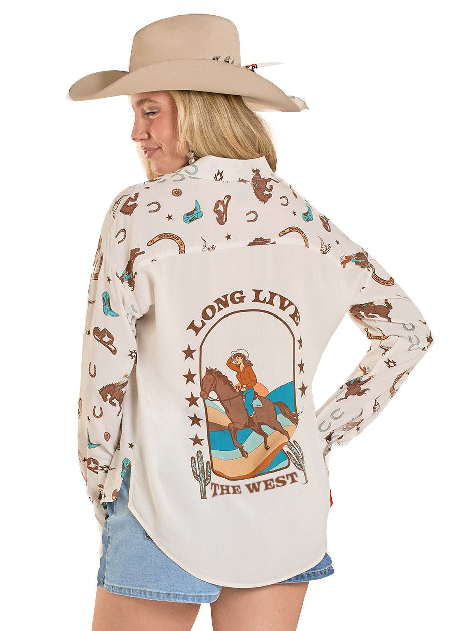 Woman wearing a long-sleeve shirt with a graphic design and cowboy boots on a white background