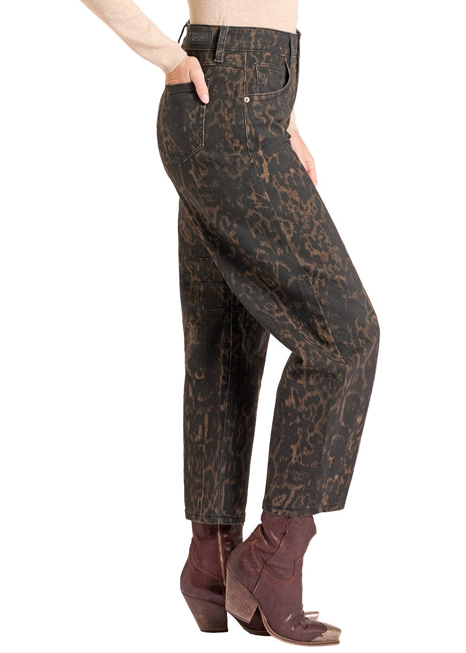 A woman modeling high-waisted cropped pants with a dark brown and black animal print, styled with a beige long-sleeve top, brown cowboy boots, and a tan cowboy hat against a white background.