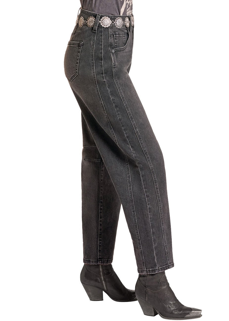 A woman modeling a dark gray graphic t-shirt, dark gray jeans with a silver western belt, a black cowboy hat, and black ankle boots, shown from a side profile against a white background.