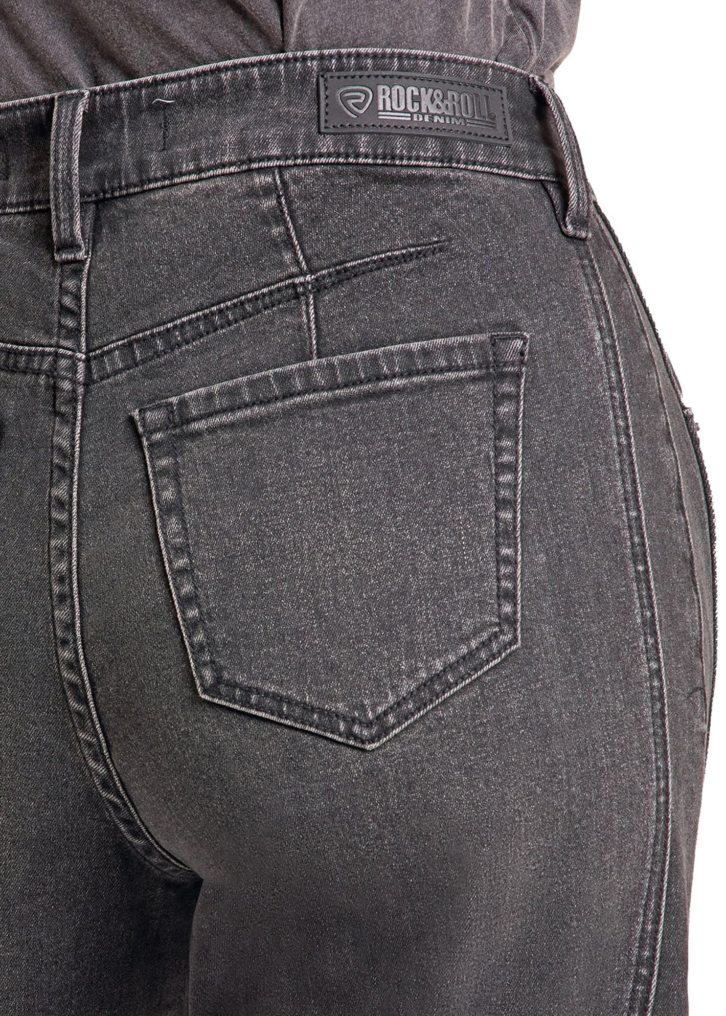 Close-up of the back waist and pocket area of dark gray washed denim jeans, showing the Rock & Roll brand patch on the waistband.