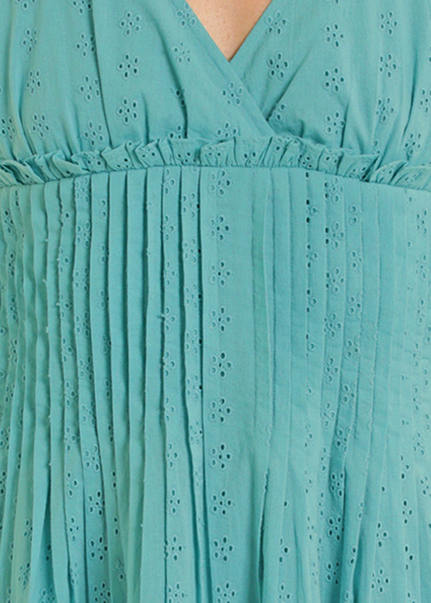 Close-up of a turquoise dress with eyelet detailing